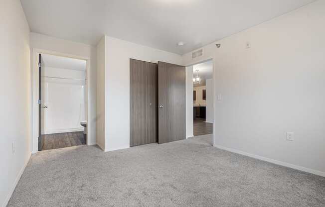 A spacious room with a carpeted floor and white walls.