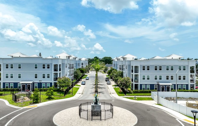 A large white building with a blue sky and white clouds in the background.