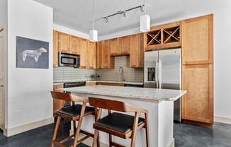 A kitchen with wooden cabinets and a marble countertop.