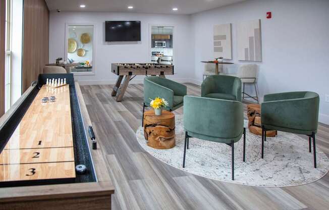 A pool table with numbered pockets is in the middle of a room with a green chair and a TV.