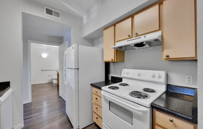 a kitchen with white appliances and wooden cabinets and a white refrigerator