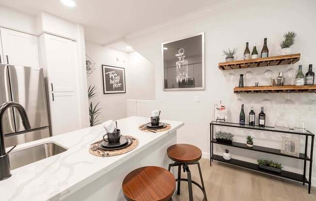 A kitchen with a white marble countertop and a wooden stool.
