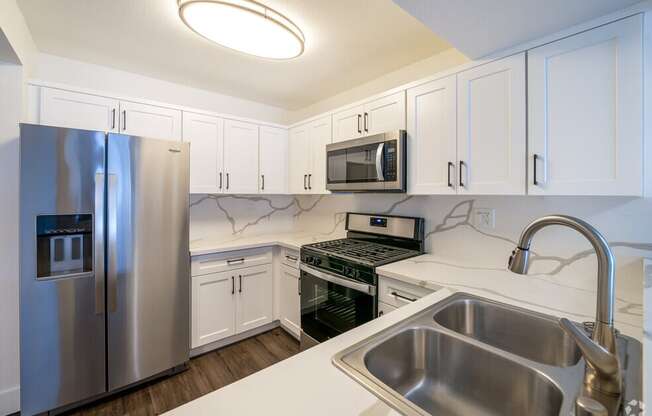 a kitchen with stainless steel appliances and white cabinets