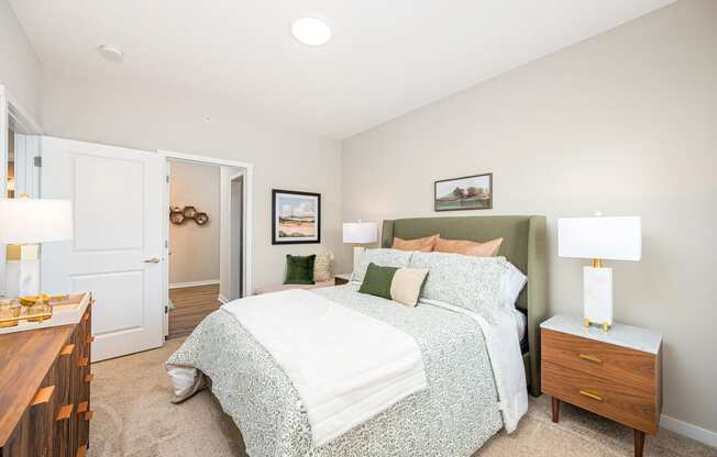 a bedroom with a bed and two lamps on top of it