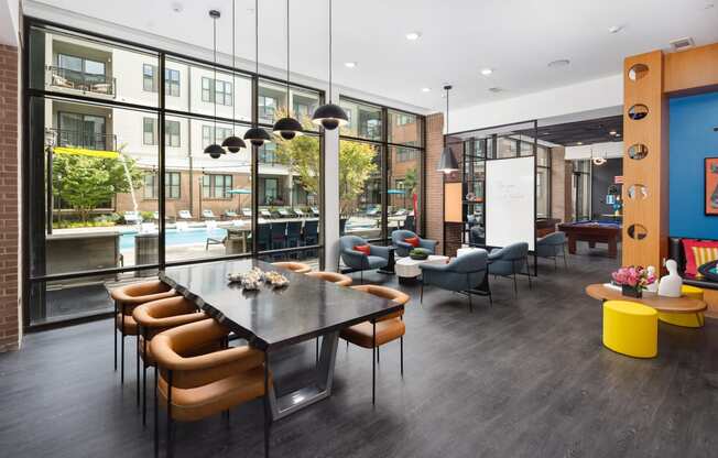 a communal area with a table and chairs and a large window