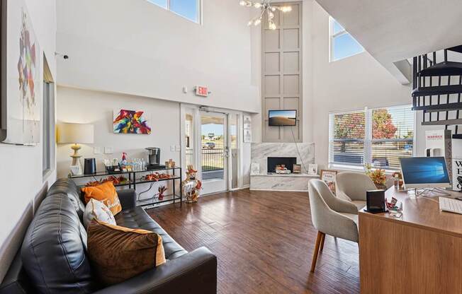 A black leather couch with a brown pillow sits in a living room.