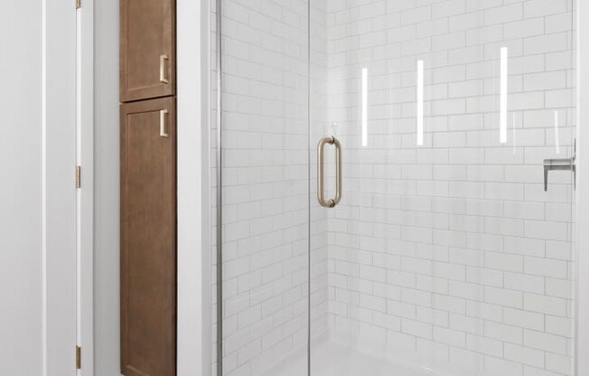 a bathroom with white tiles and a glass shower door