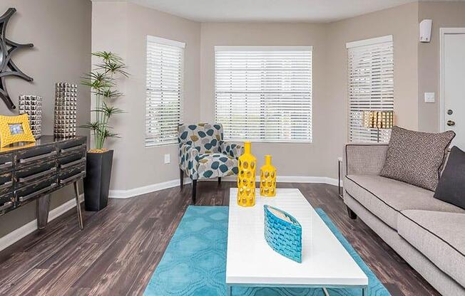 A living room with a couch, a coffee table, and a window with blinds. at Bradford Pointe, Augusta, 30909