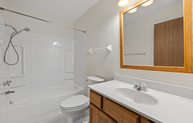 A white bathroom with a toilet, sink, and tub.