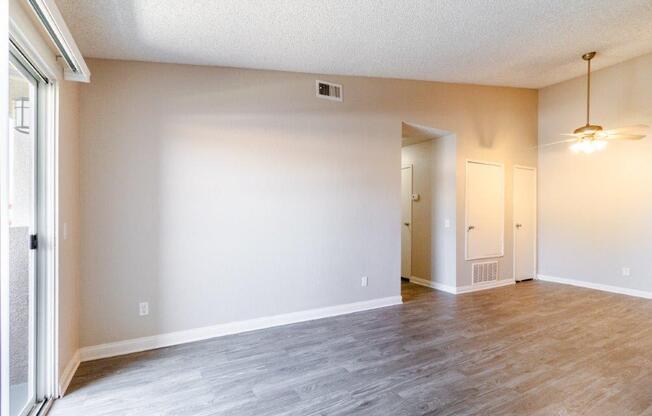 an empty living room with white walls and a wood floor