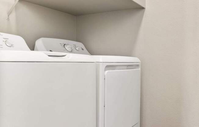A white dryer and washer in a small laundry room.