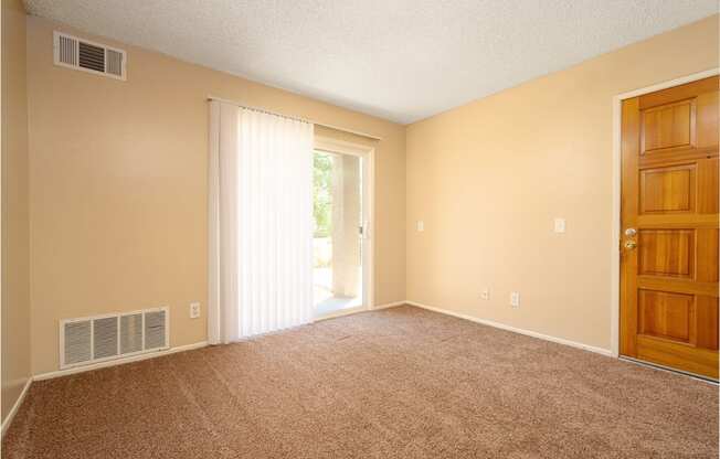 a bedroom with a door leading to a patio at Oak Terrace Senior Apts, Hemet, CA