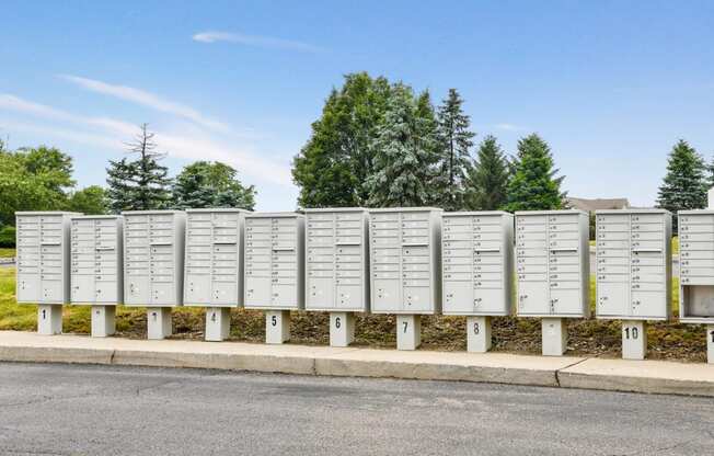 a row of white mailboxes on the side of a street