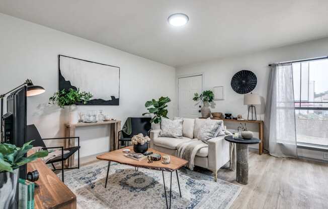 a living room with white walls and hardwood floors