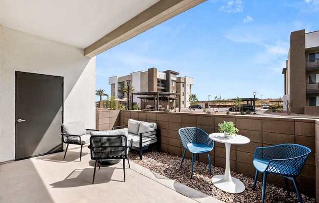 A patio with a table and chairs overlooking a building.