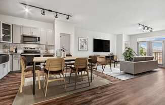 an open living room with a dining room table and chairs and a kitchen