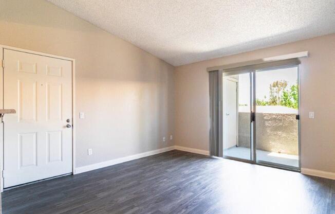 an empty living room with a door to a patio