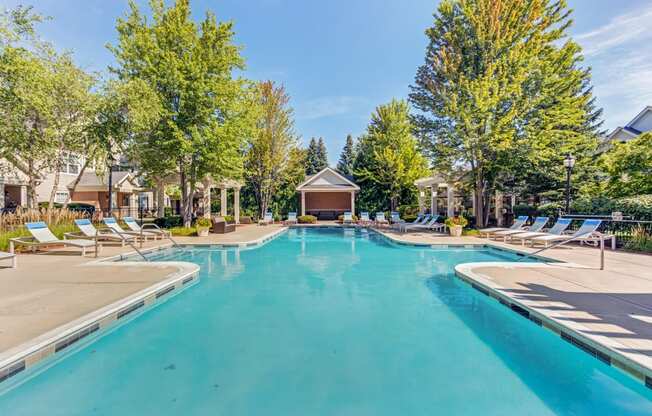Aurora, IL Townhomes - The Apartments At Kirkland Crossing - Pool With Lounge Chairs And Trees Surrounding.