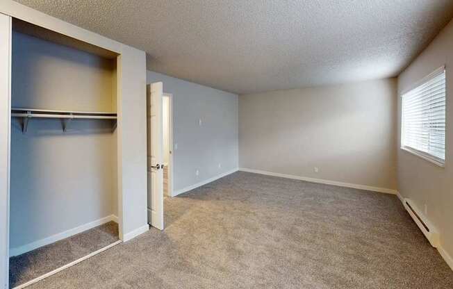 Spacious bedroom at Peak 88 Apartments in Renton WA with soft carpet, large closet, and neutral paint tones.