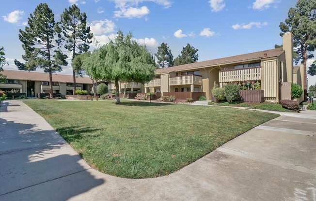 a building with a lawn and trees in front of it at Summerwood Apartments, Santa Clara, CA