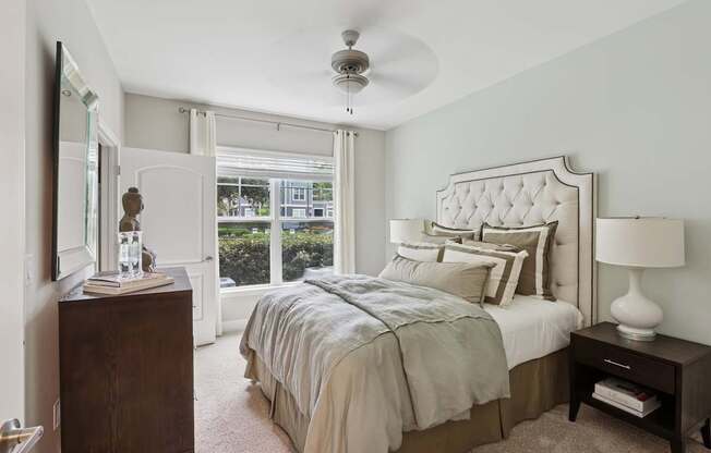 A bedroom with a large bed and a ceiling fan.