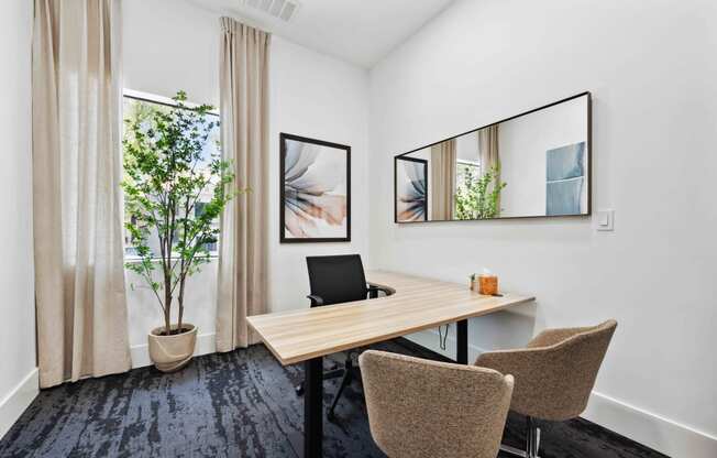 a workspace with a desk chairs and a potted plant