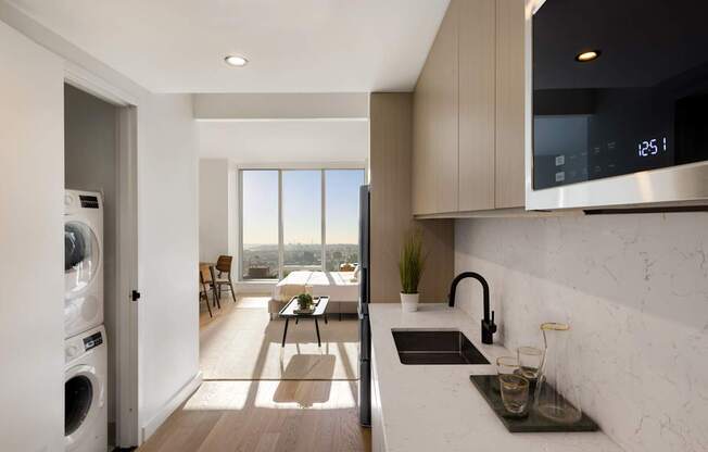 a kitchen with a sink and a dishwasher and a living room with a window at The Paxton, Brooklyn, NY 11201