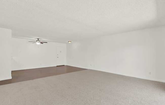 the spacious living room with white walls and a ceiling fan at Camino de Oro Apartments, Torrance, California