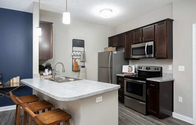 a kitchen with stainless steel appliances and a marble counter top