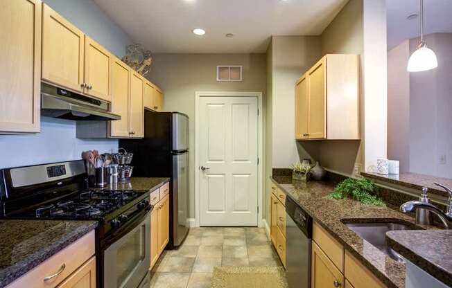 A kitchen with wooden cabinets and granite countertops.