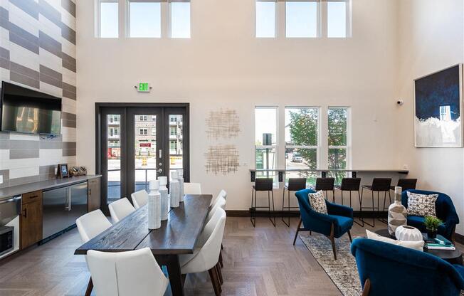 a dining room with a table and chairs and a living room with high ceilings