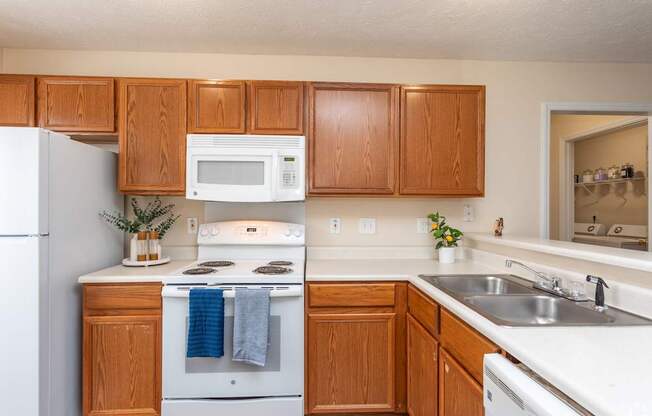 A kitchen with wooden cabinets and white appliances.