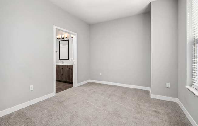 A room with a carpeted floor and a doorway leading to another room.