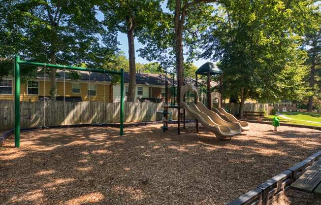 a playground with a slide and monkey bars in front of a house