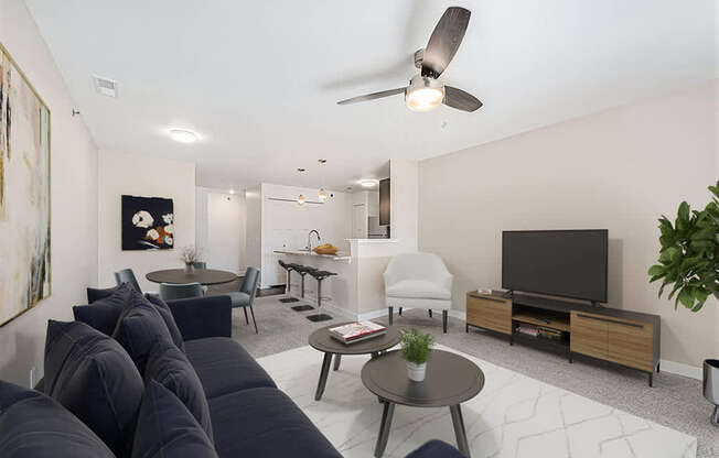 A living room with a dark blue sofa and a television at Copper Creek Apartment Homes, Maize, Kansas