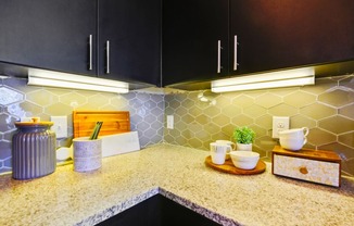 a kitchen with black cabinets and a counter top at South Side Flats, Dallas, Texas