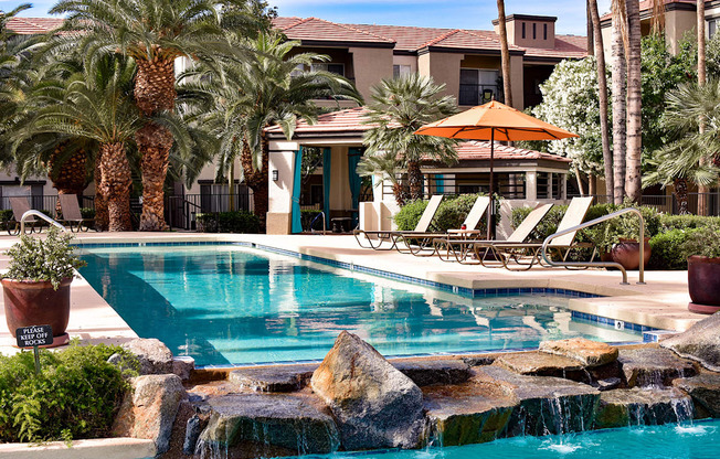 resort-style surrounded by poolside chaise lounge chairs, large palm trees