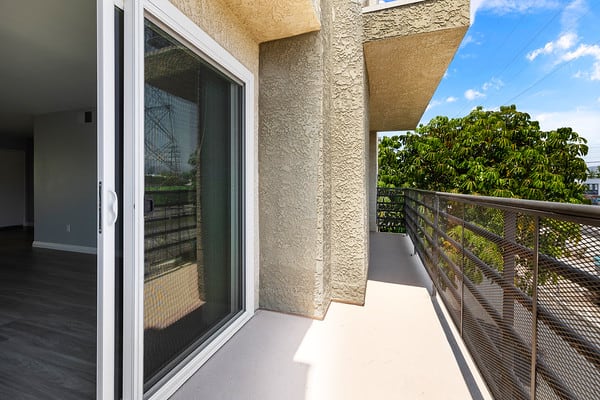 a balcony with a glass door and a wooden railingat NOHO GALLERY Apartments, North Hollywood , 91601