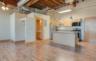 A kitchen area with wooden floors and a counter.