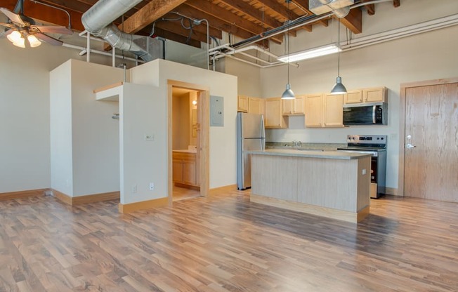A kitchen area with wooden floors and a counter.