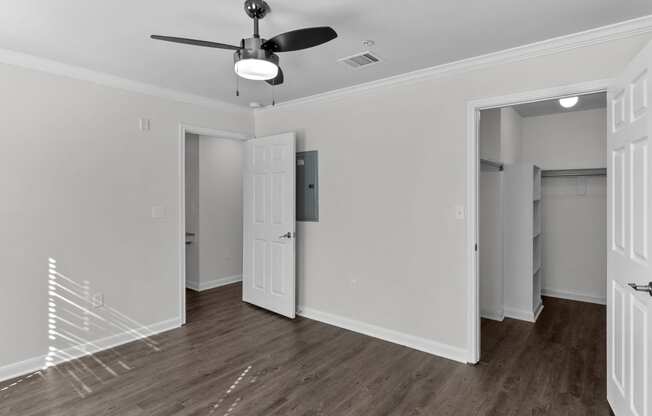 an empty room with white walls and a ceiling fan