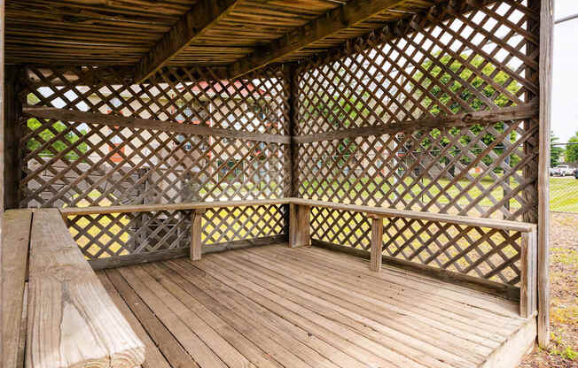 a gazebo with a wooden deck and a bench at Sutton Hill Apartments, IOWA, 50320