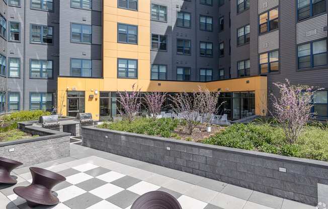 a view of the courtyard of an apartment building with a checkered sidewalk