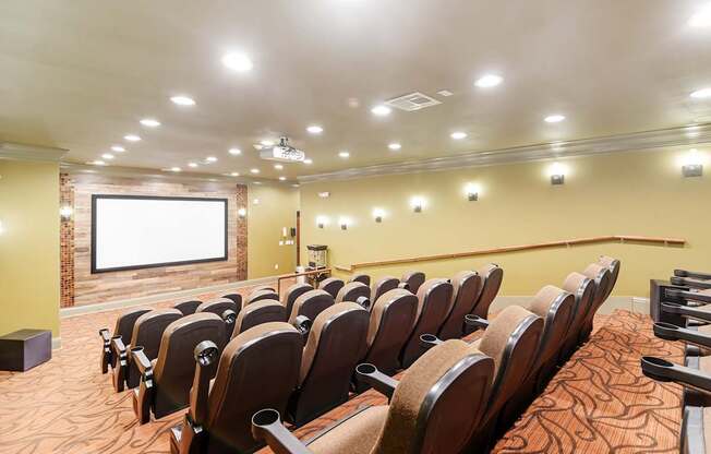 a conference room with a projector screen and chairs at Cumberland Place Apartment Homes, Texas