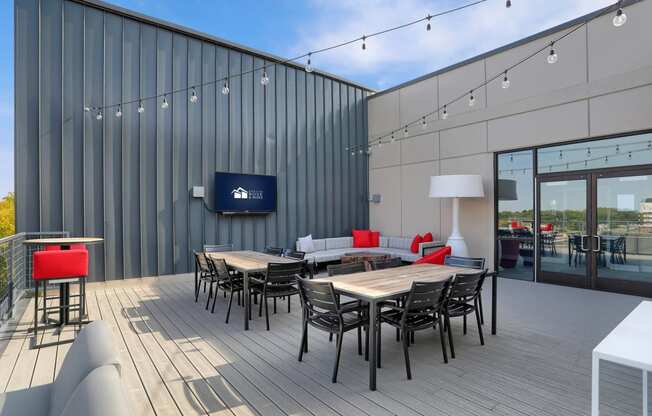 a patio area with tables and chairs and a tv