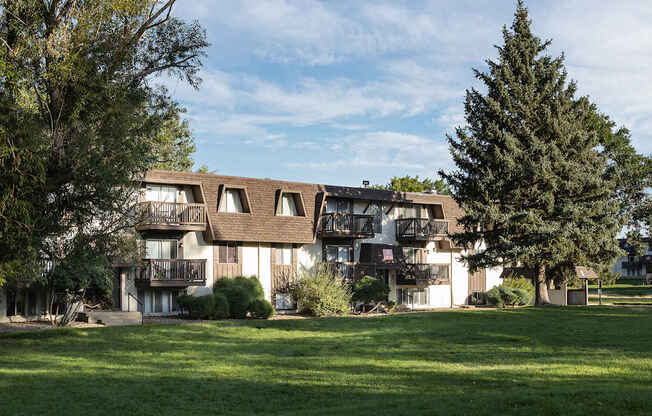 A large building with a balcony and a tree in front of it.