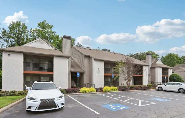 A white Lexus is parked in a parking lot in front of a building.