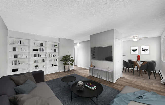 A living room with a grey couch, a black coffee table, and a bookshelf filled with books.