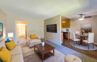 A living room with a couch, chairs, and a television.