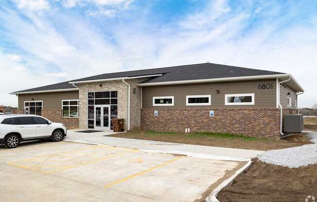 A white car is parked in front of a building with the number 8801 on it.